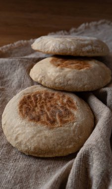 Close-up of Traditional Portuguese flat circular bread Bolo Do Caco on textile background. Madeira island cuisine.