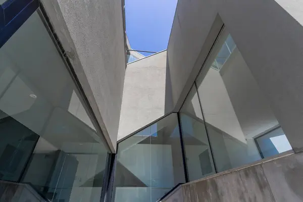 Gri beton ve cam kaplı modern bir konut binasının yakın çekim detayları.