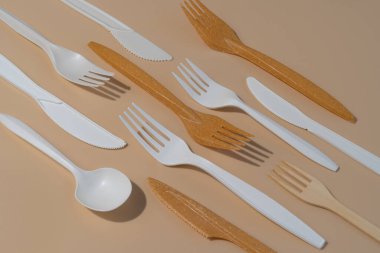 Bej arka planda çevre dostu tek kullanımlık aletler. Plastiğe karşı biyolojik olarak çözünebilir, düzenlenebilir alternatif.