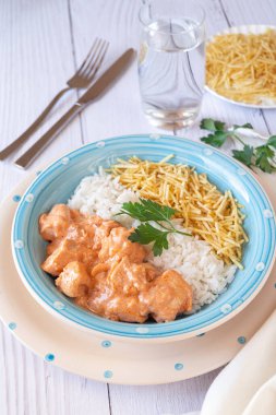 Beyaz ahşap masada pilav ve patates pipetli Chicken Strogonoff yakın çekim. Brezilya mutfağı..