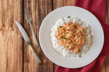 Brezilya usulü Tavuk Strogonoff 'u. Tahta masada pilav ve patates kamışı. Düz yat, boşluğu kopyala