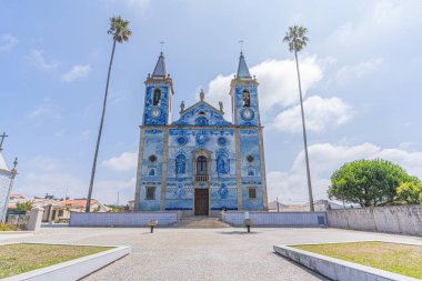 Cortegaca, Portugal - 20 June 2023: tipical blue tiled portuguese church with palm trees, Igreja de Santa Maria de Cortegaca clipart