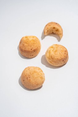 Beyaz arka planda Brezilya peynirli çörekler, sert gölgeli minimalizm