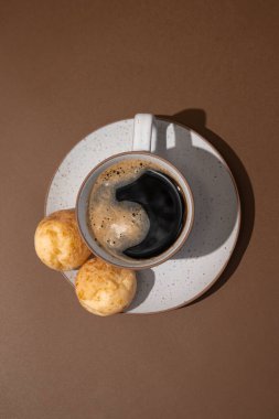 Brezilya peynirli ekmekli kahve fincanının üst görüntüsü - kahverengi arka planda pao de queijo