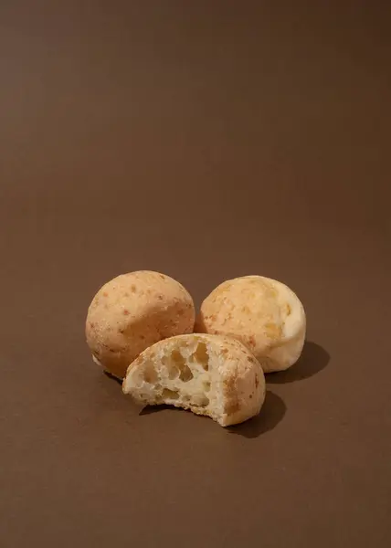 Dört Brezilya peynirli ekmek - kahverengi arka planda pao de queijo