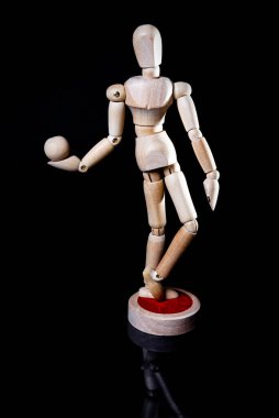 Siyah arka planda düşen tahta manikin resmi, tahta manikin farklı pozlar veriyor.