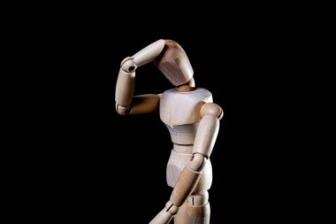 Siyah arka planda düşen tahta manikin resmi, tahta manikin farklı pozlar veriyor.