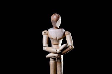 Siyah arka planda düşen tahta manikin resmi, tahta manikin farklı pozlar veriyor.