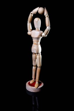Siyah arka planda düşen tahta manikin resmi, tahta manikin farklı pozlar veriyor.