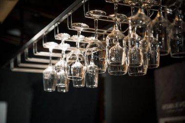 İnsanlar yaz terasında kafeteryada ya da restoranda bardakları şarapla tokuşturuyor, ellerinde cam şişeyle arka planda...