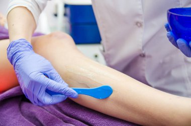 Doktor kozmetik uzmanı bir hastaya lazer cilt yenileme prosedürü uygular. Tıbbın arka planında fotokopi alanı var..