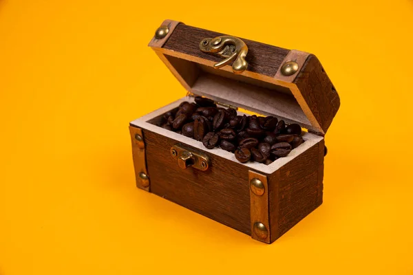 chest with coffee , Image of middle-aged coffee beans. Poured into a pirate chest. Precious, expensive, tonic, invigorating, fragrant, delicious, high-quality, roasted drink. Brown, glossy grains