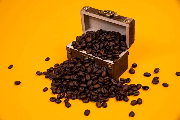 chest with coffee , Image of middle-aged coffee beans. Poured into a pirate chest. Precious, expensive, tonic, invigorating, fragrant, delicious, high-quality, roasted drink. Brown, glossy grains