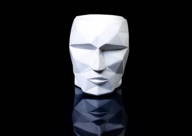 Vazo olarak destekle, ön tarafa odaklan. Siyah arka planda bir yüz şeklinde alçı vazo. izole