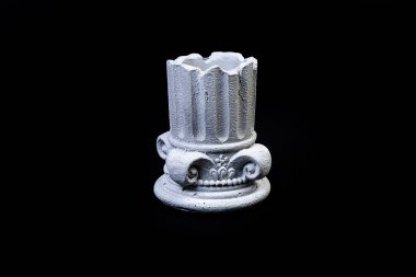 Alçıtaşı sütunlu bir kâse, çiçek süsü şeklinde bir vazo, antika bir sütun şeklinde alçı vazo. Modern sanat. Siyah bir arkaplanda modern tasarım izole edildi