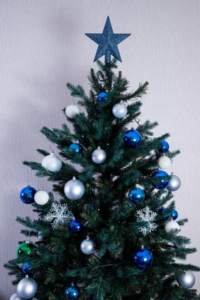 五彩缤纷的圣诞树 白色砖墙上挂着蓝球和白球的礼品盒 — 图库照片