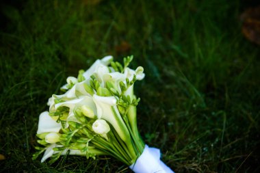 Doğa konsepti yaprakları için farklı egzotik sazlık yaprakları olan güzel düğün dekorasyonları. Hoş geldin buketi. Güllü buket, şakayık, gelin ve damat için calla