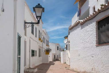 İspanya 'nın Menorca kentindeki Binibeca Nou adlı turistik balıkçı köyünün sokakları ve beyaz duvarları.