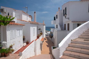 İspanya 'nın Menorca kentindeki Binibeca Nou adlı turistik balıkçı köyünün sokakları ve beyaz duvarları.