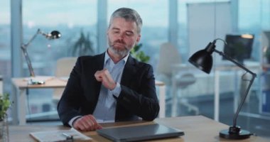 Yetişkin Kafkasyalı işadamı ofisini bitiriyor ve cep telefonunu takım elbisesinin cebinde arıyor. İş adamı demek. Ofis çalışma alanı.