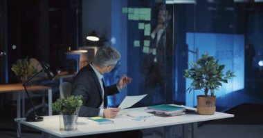 Yetişkin ve genç iş adamlarından oluşan şirket ekibi ofiste iş birliği yapıyor. Uzun saatler boyunca pazarlama fikirleri üzerinde çalışıyorlar..