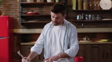 Yakışıklı, olgun bir adam gazete başında iyi haberler okuyor. Mutfakta kahvaltı ederken işi için başarılı fikirler üretiyor..