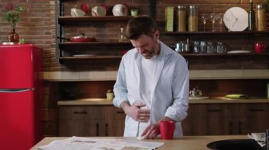 Modern dekorasyon ve modern tasarım unsurlarıyla şık bir mutfakta duran bir adam kendini rahatsız hisseder.