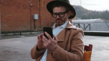 Şehrin yukarısında güzel vakit geçiren şık bir moda tasarımcısının portresi. Ekrana bakan akıllı telefondan mesaj atan sosyal iş adamlarının yakın plan görüntüleri..