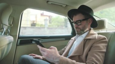 Eski İngiliz kıyafetleriyle modern bir akıllı telefon kullanarak lüks bir araba sürerek internet haberlerini izleyerek milyonlar kazanacağız..