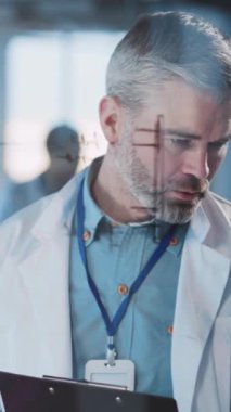 Bu video laboratuvar önlüklü bir araştırmacının verileri gözden geçirmesini, bir telefonu görüş için kullanmasını ve röntgen çekerek bilimsel bir ithafı incelemesini içeriyor.