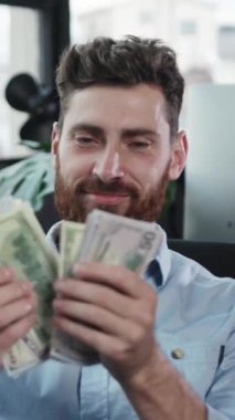 Neşeli bir adam, hem finansal başarıyı hem de derin bir mutluluk duygusunu simgeleyen yüklü miktarda para tutuyor.