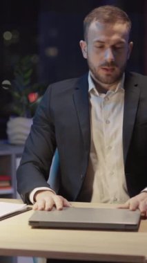 Resmi olarak Kafkasyalı genç ofis yöneticisi masa başı bilgisayar masaüstü dizüstü bilgisayarı giyer ve işini gece bitirir. İşkolik insanlar. Şirket personeli. Modern iç mimari.
