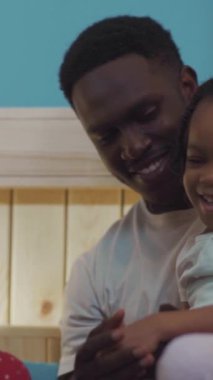 Şefkatli bir adam küçük bir kızı kucaklıyor, hassas bağlarının altını çiziyor. Telefonunu kontrol ederken, Joya 'nın aşk ve bağlantı anlarıyla ışıldıyor.