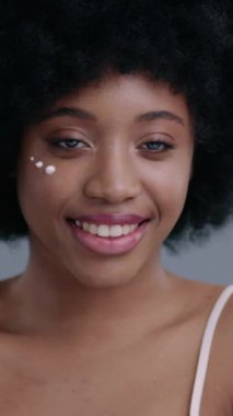 Genç bir kadın, güzel, ışıl ışıl tenini sergiliyor, neşeli bir gülümseme eşliğinde, huzurlu bir ortamda.