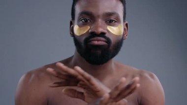 Cilt bakımını ve özgüvenini arttıran altın maskeler takan bir adam.