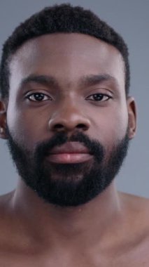 Derin düşünen, kıvırcık saçlı ve sakallı bir adamın özünü gösteren yakın plan bir portre.