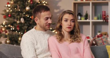 Çekici bir adam güzel bir ambalajla hediye veriyor ve kıza kırmızı fiyonk takıyor. Sürpriz mutlu kız kucaklaşması erkek arkadaş. Kapalı.