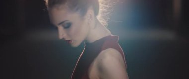 Karmaşık saç stili ve yumuşak ışıklandırmayla aydınlatılmış büyüleyici bir kadın profili.