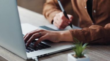 Güzel görünümlü bir kız bilgisayar masasında oturuyor ve çalışıyor. Yuvarlak gözlüklü genç kahverengi saçlı kadın monitör ekranına bakıyor. Yakın plan..