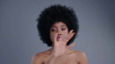 Oldukça egzotik bir Afrikalı Amerikalı kızın portresi gri arka planda geleceğin teknolojisine dokunuyor ve kullanıyor.