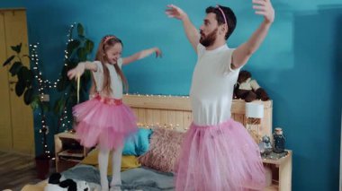 Aile partisinde sihirli perileri oynayan baba ve kızı hoş bir manzara. Mutlu genç adam ve küçük kız ayak parmaklarını çekiştirip balerin pozu veriyorlar. Birlikte eğleniyorlar..