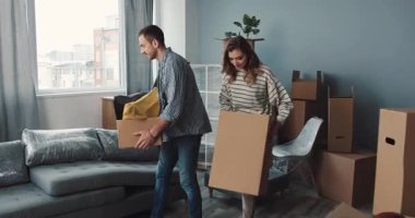 Bir adam titizlikle yeni dairesini düzenliyor. Bir sürü taşınan kutu ve çeşitli mobilyayla dolu.