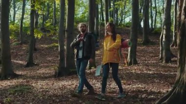 Genç Kafkasyalı gezginler yeşil ormanda yürürler, gülerler, birbirleriyle konuşurlar. Hayatın, doğanın, sakinliğin tadını çıkarıyorum. Romantik atmosfer, eğlenmek, çıkmak. Kamera dengeleyici görüntüsü