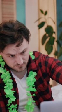 Şık yeşil bir kolye takan düşünceli genç bir adam, rahat ve rahat bir iç mekanda yakalanır.