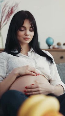 Huzurlu ve huzurlu bir an, hamile bir kadının doğmamış çocuğuyla evinin rahatlığında derin bir bağ kurmasıyla meydana gelir.