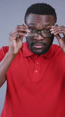 Gri arka planda şık gözlükler takan yakışıklı Afro-Amerikan bir adamın yakın görüntüsü. İş adamı, yaratıcı süreç, beyin fırtınası, ofis. Erkek portresi