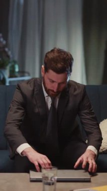 İşkolik işadamı eve döndüğünde evde uzun saatler çalışan laptop açma cihazını kontrol ederken yorgun hisseder. Modern yaşam tarzı.