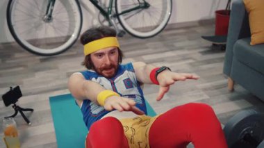 Komik gergin sporcu pizzaya ulaşmaya çalışırken egzersiz minderinde mekik çekiyor. Abur cubur ve spor konsepti.