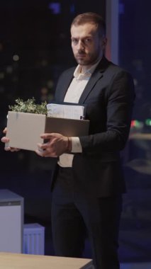 Genç mutsuz yetişkin erkek modern ofis şirketini iş kaybından dolayı hayal kırıklığına uğratıyor. İş krizi konsepti. İşsizlik Kurumu.