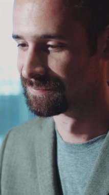 Bu ilgi çekici video, yeşil ceketli ve mavi gömlekli karizmatik bir adamın neşe ve samimiyet paylaştığını, dostça gülümsemesini ve olumlu havasını yakaladığını gösteriyor.